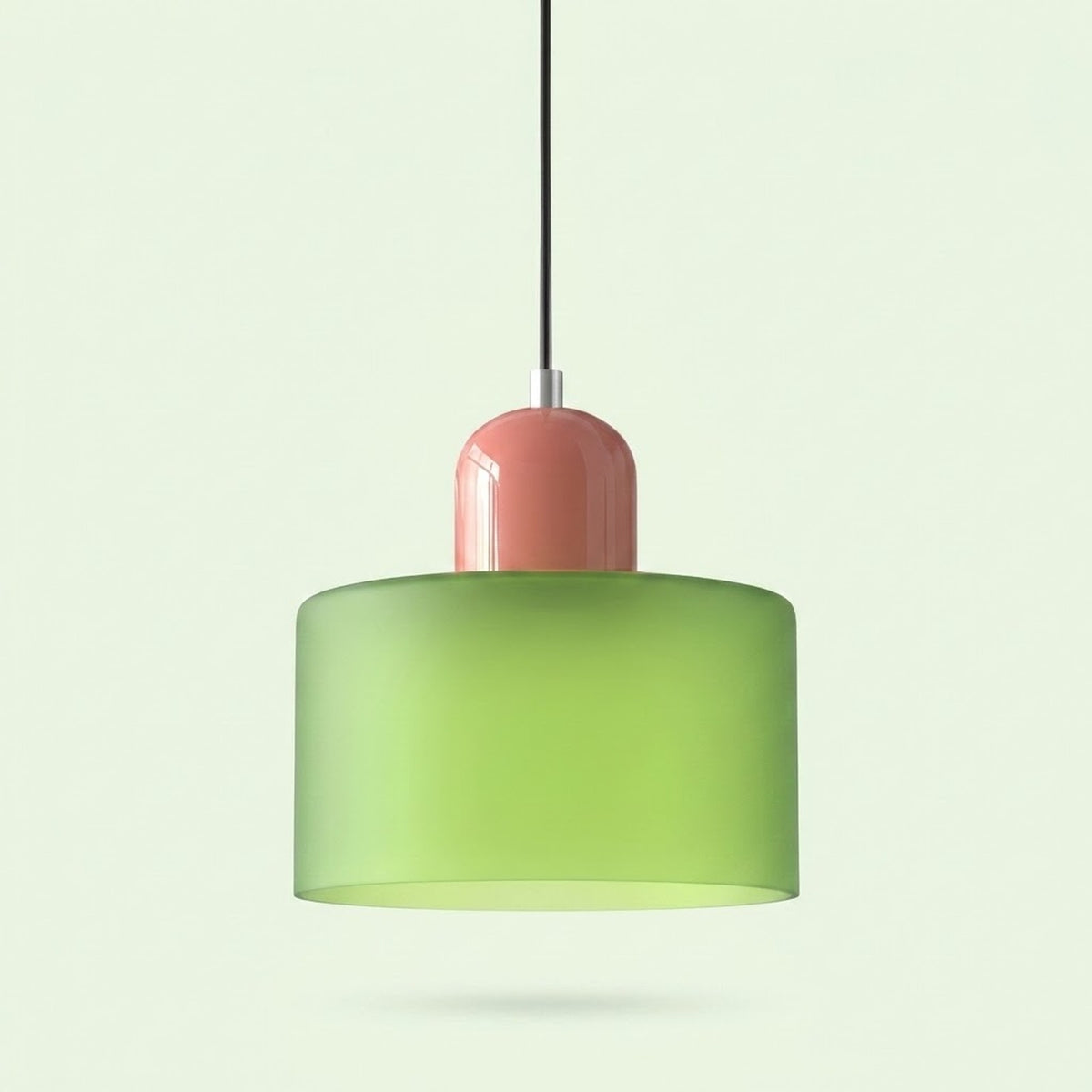 A chandelier with a light green glass drum shade and glossy pink cap hangs against a pale green background.
