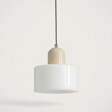 A chandelier with a white glass drum shade and rounded beige cap hangs from a black cord against a pale background.