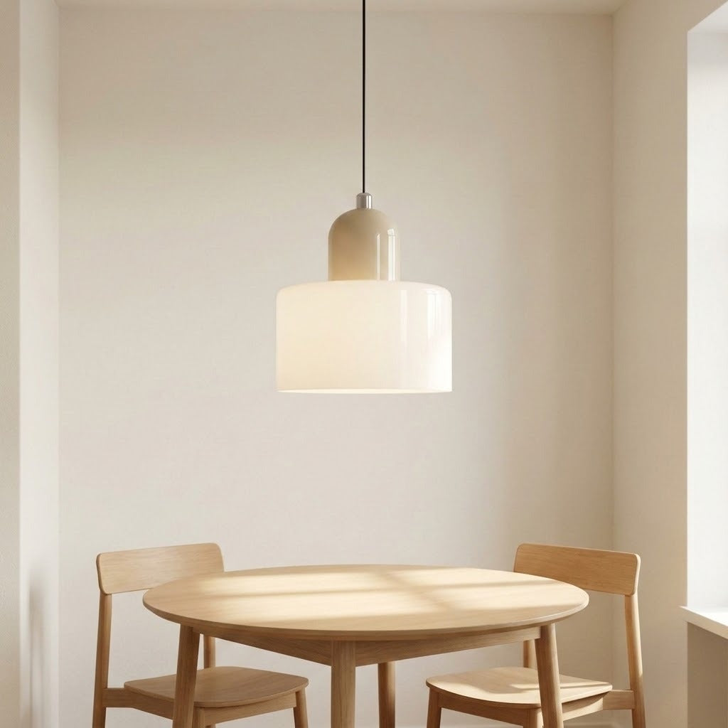 A white glass chandelier with a beige rounded top hangs above a round wooden dining table with two chairs.