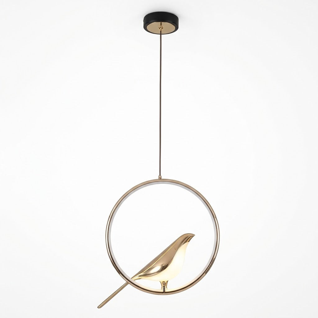 A modern pendant light fixture featuring a gold-toned bird silhouette inside a thin circular metal frame, suspended by a cord from a round black ceiling canopy against a plain white background.