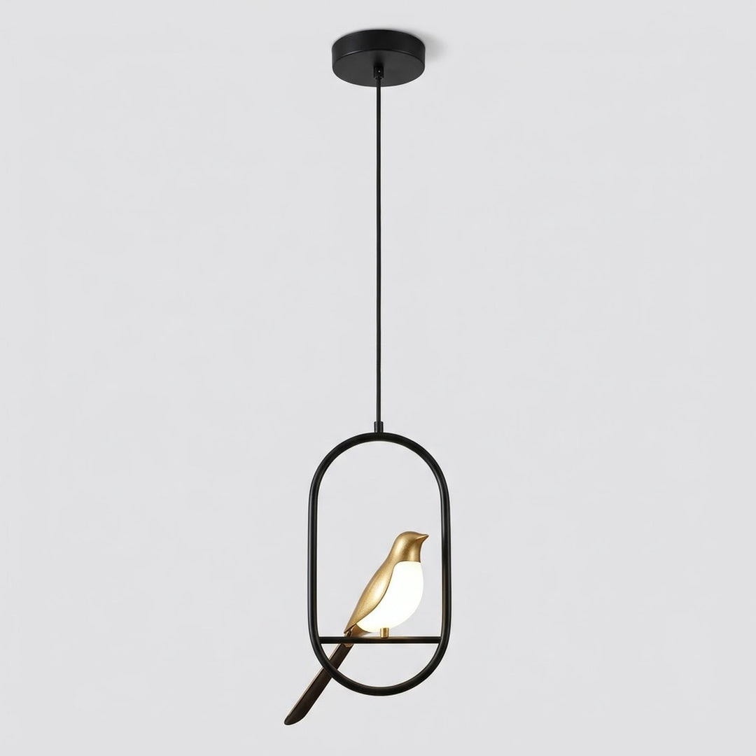 A modern pendant light fixture with a black metal frame and rod, featuring a small gold bird figurine with a glowing white light inside, suspended from a black ceiling canopy against a light gray background.
