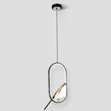 A modern pendant light with a black circular ceiling canopy, a thin black cord, and an oval frame with a gold-toned leaf-shaped shade inside, shown against a light gray background.