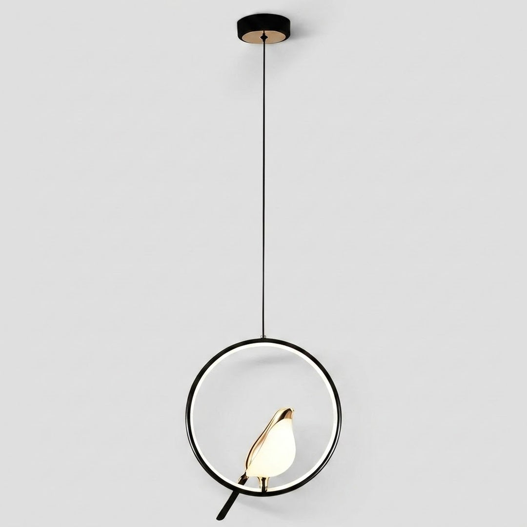 Modern pendant light fixture with a black circular ring, black cord, and a warm glowing white and gold leaf-shaped bulb, shown against a light gray background.