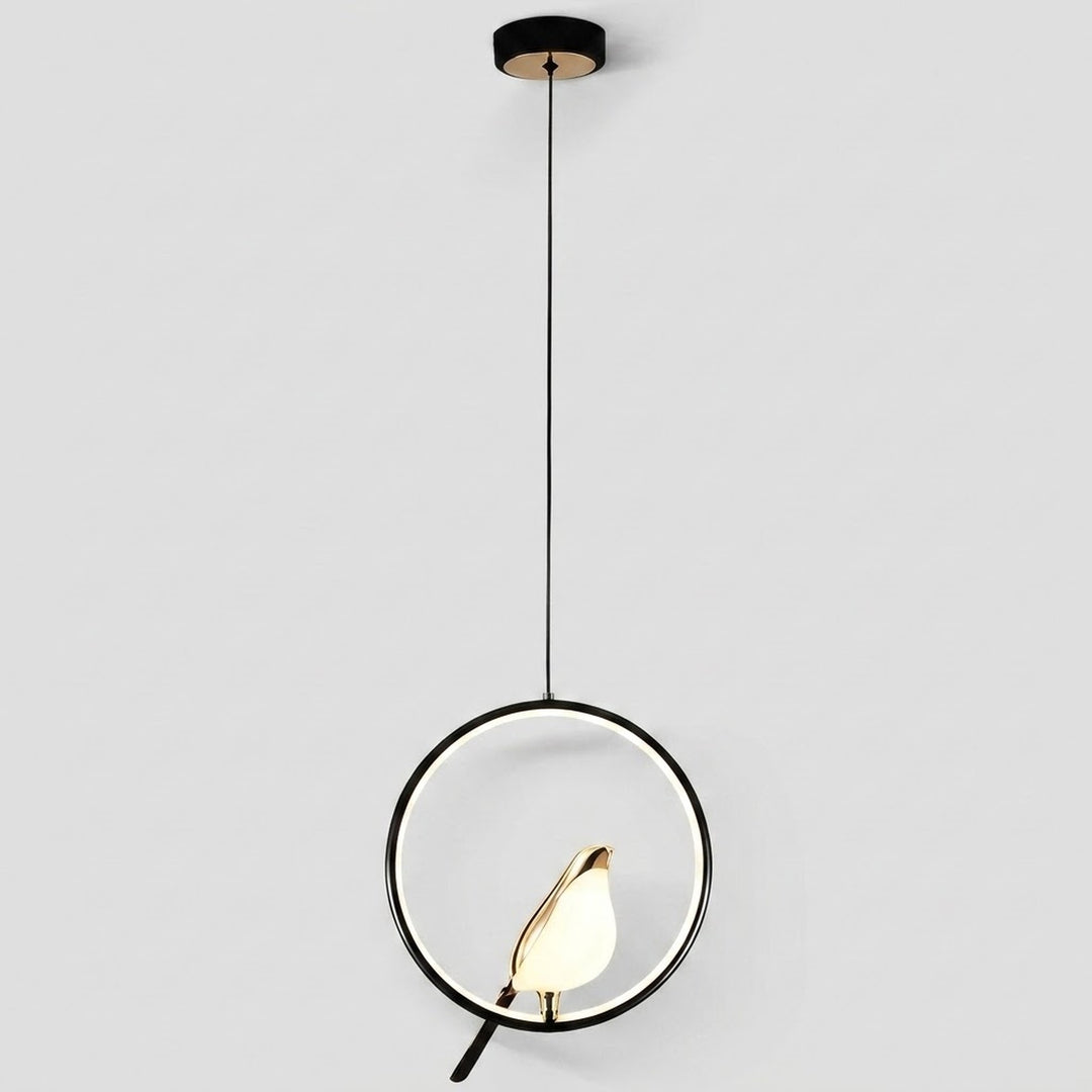 Modern pendant light with a black circular frame, black cord, and a small gold bird-shaped shade holding a glowing white bulb, shown against a light gray background.