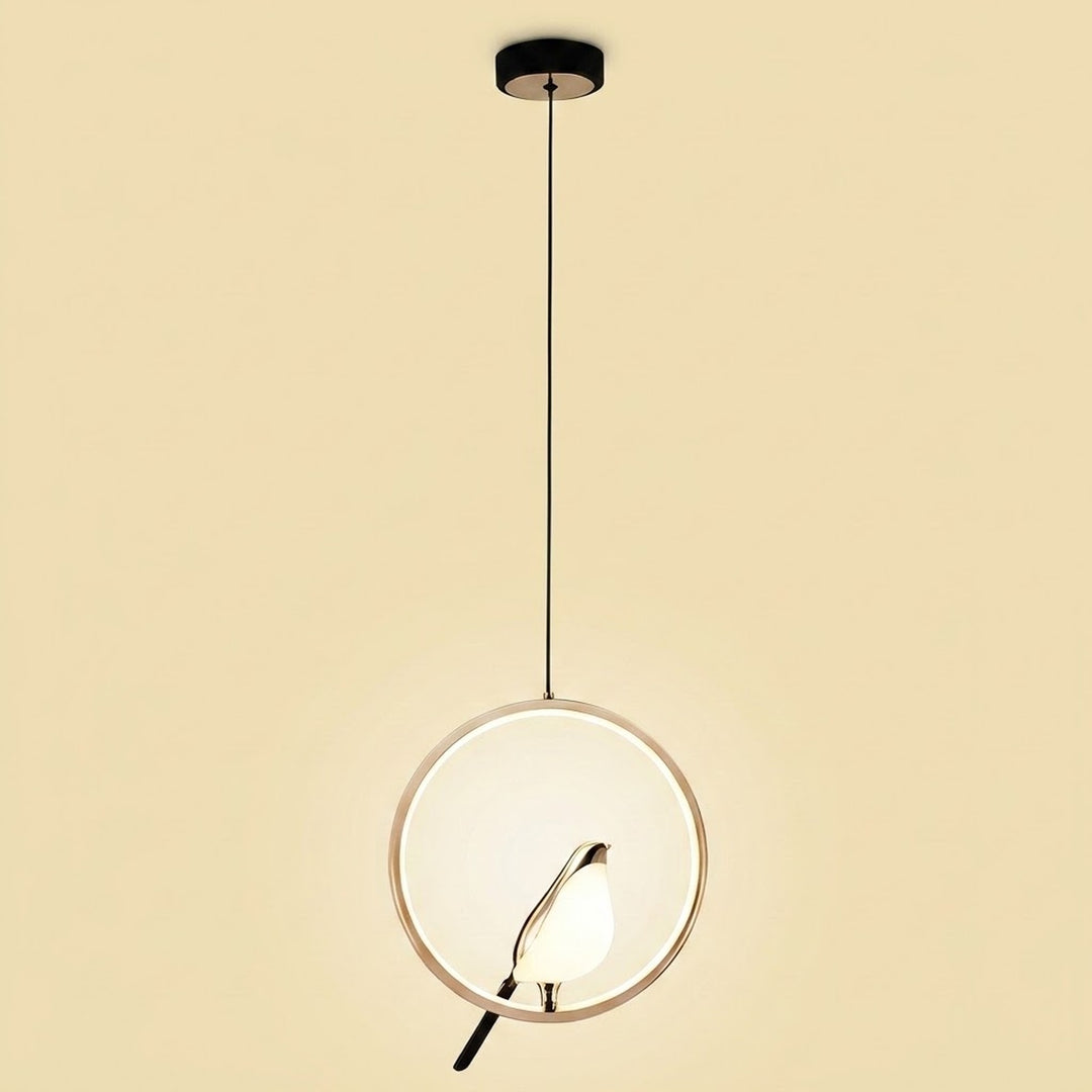 A modern pendant light with a circular white glass shade, a thin gold-toned metal frame, and a black hanging rod and canopy, shown against a solid beige background.