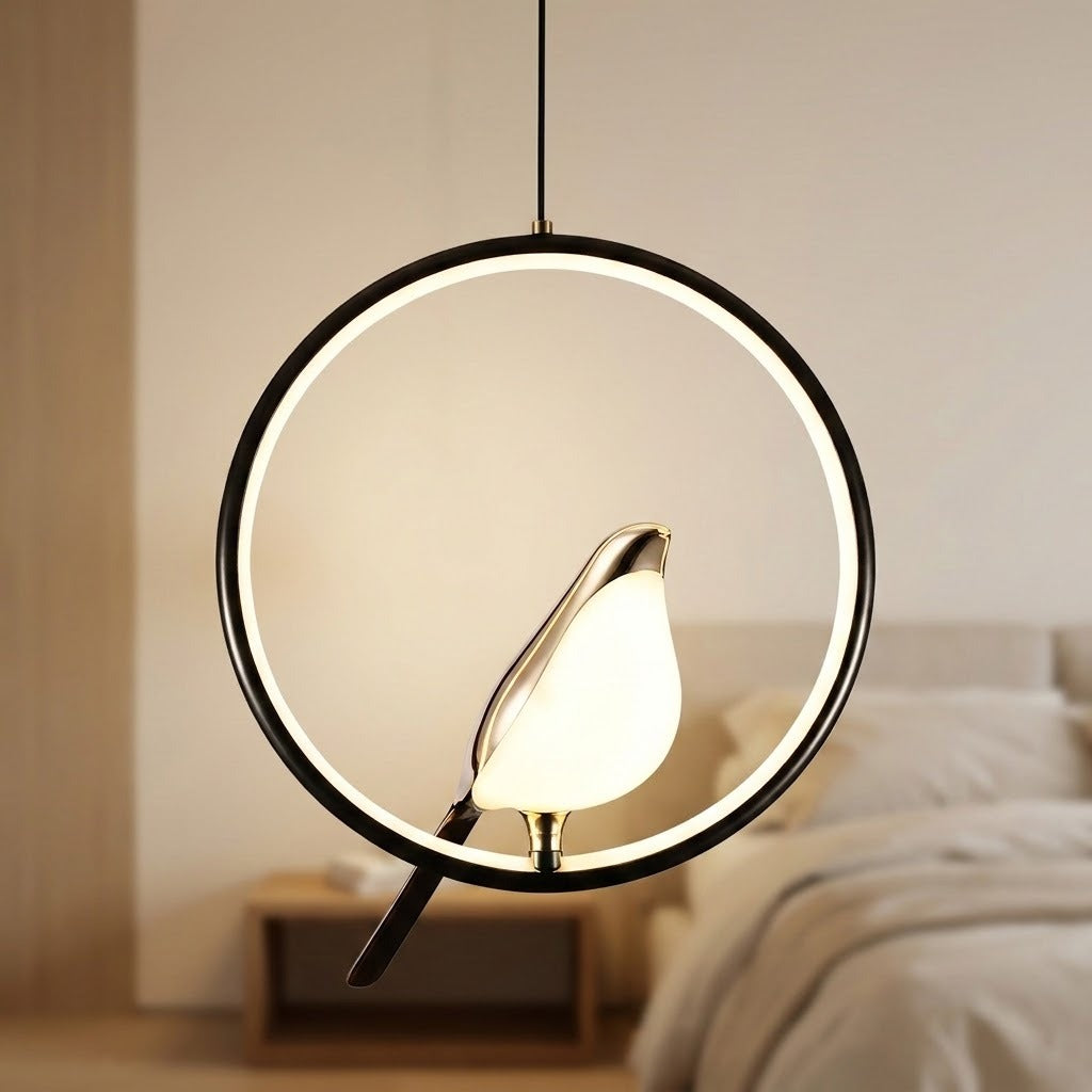 A modern circular pendant light with a glowing white LED ring and a bird-shaped lamp in the center, hanging in a softly lit bedroom setting.