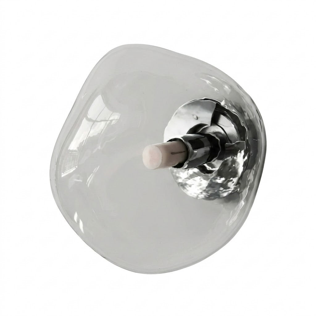 Wall sconce with an irregular clear glass shade and polished silver mounting hardware stands alone against a white background.