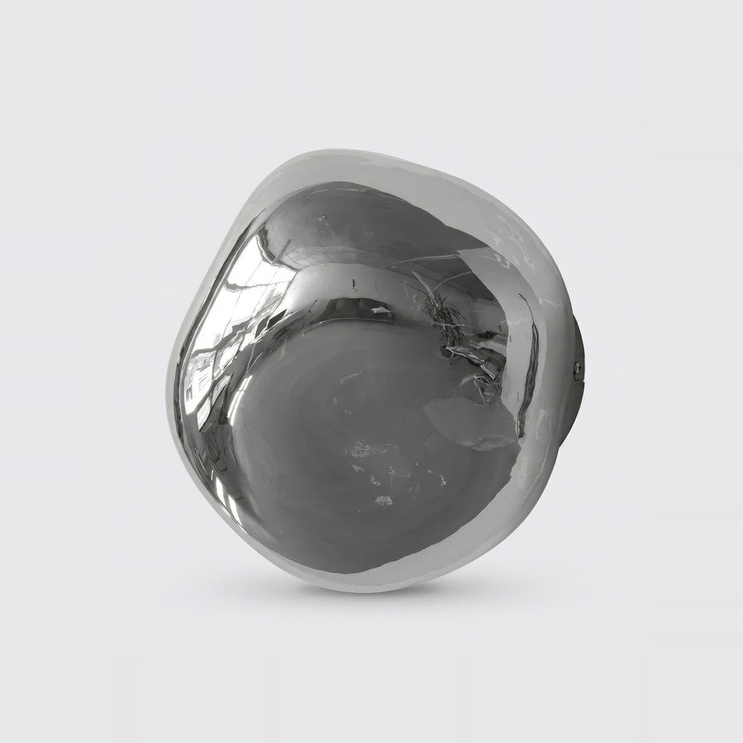 Chrome glass wall sconce with an asymmetrical rounded shade and dark mounting base visible behind it against a light gray background.
