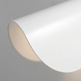 A close-up of a white wall sconce shows its smooth curved shade and softly illuminated inner surface against a gray background.