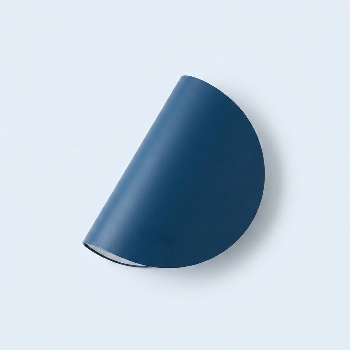 A modern semi-circular wall sconce in a matte dark blue finish, shown mounted on a light gray wall.