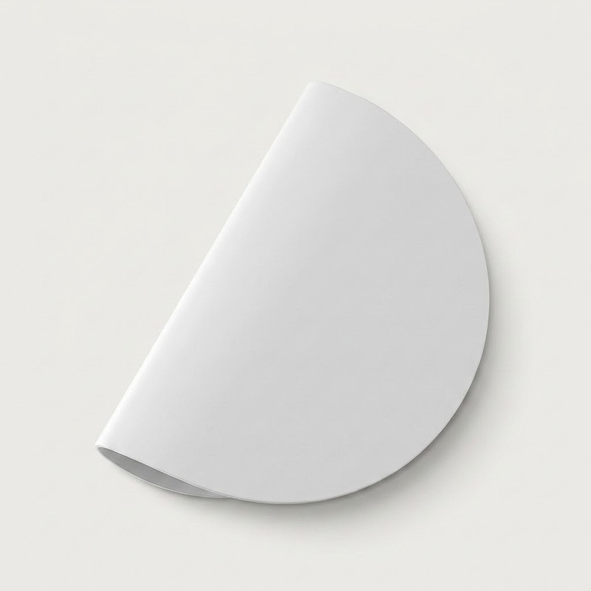 A white wall sconce with a smooth semicircular shade sits diagonally against a light background with a soft shadow.