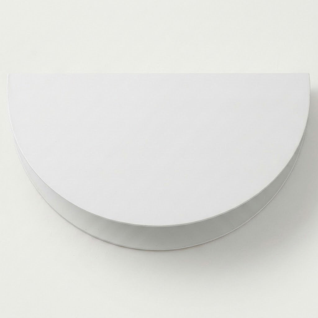 A white wall sconce with a semicircular shade and curved lower housing appears against a plain light background.