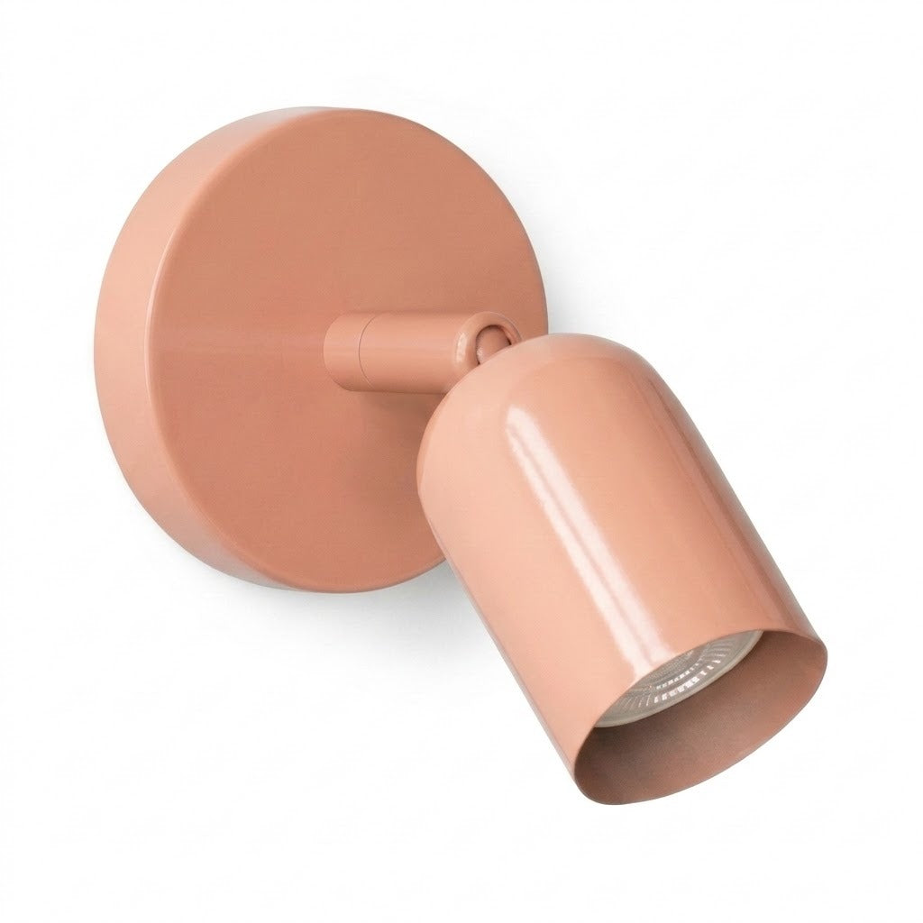 A glossy pink wall sconce with a round mounting plate and adjustable cylindrical shade on a plain white background.