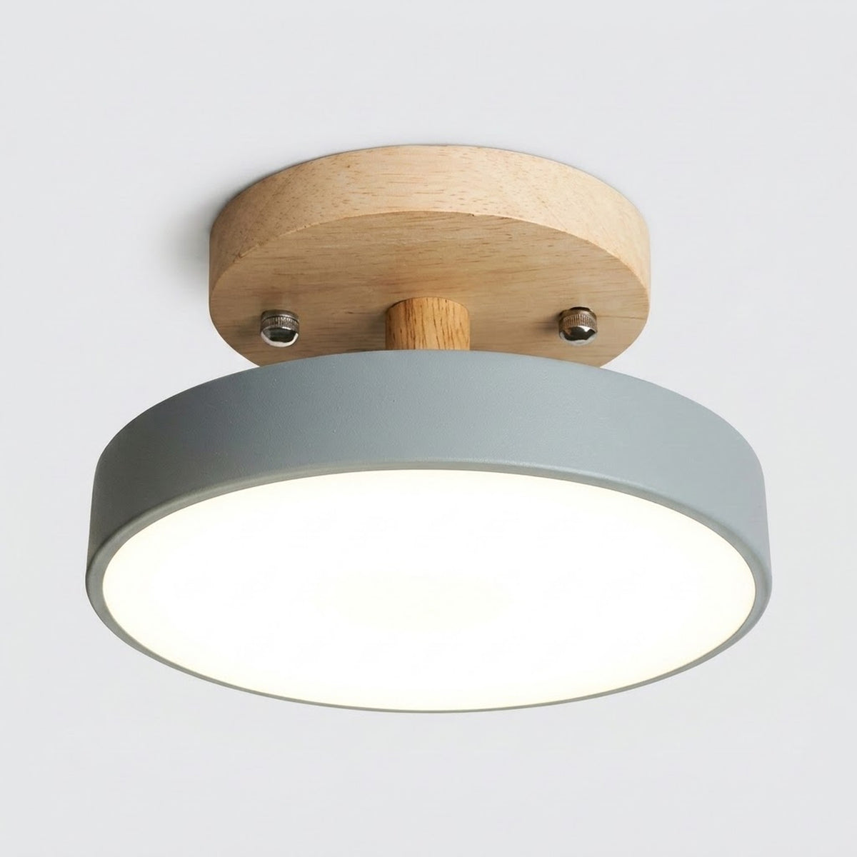 A modern semi-flush mount ceiling light with a matte gray cylindrical shade, a natural wood ceiling canopy, and a small wooden stem, shown illuminated against a light gray background.
