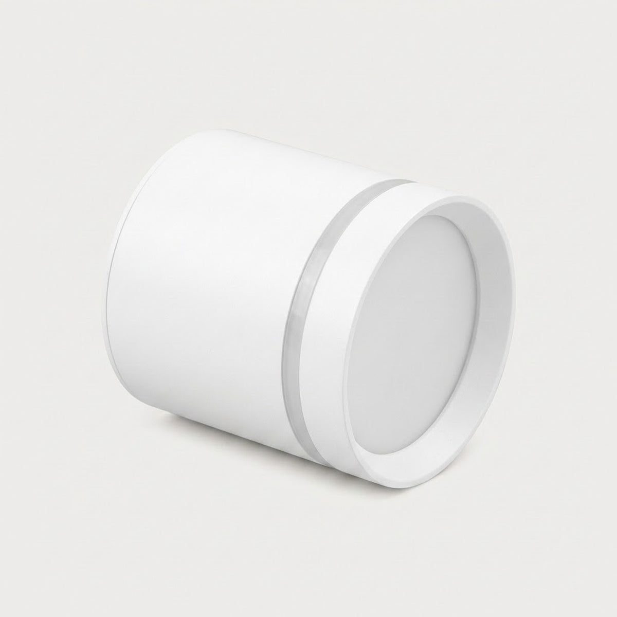 A white cylindrical LED downlight lies angled on a light gray background, showing its circular diffuser and silver-colored accent ring.