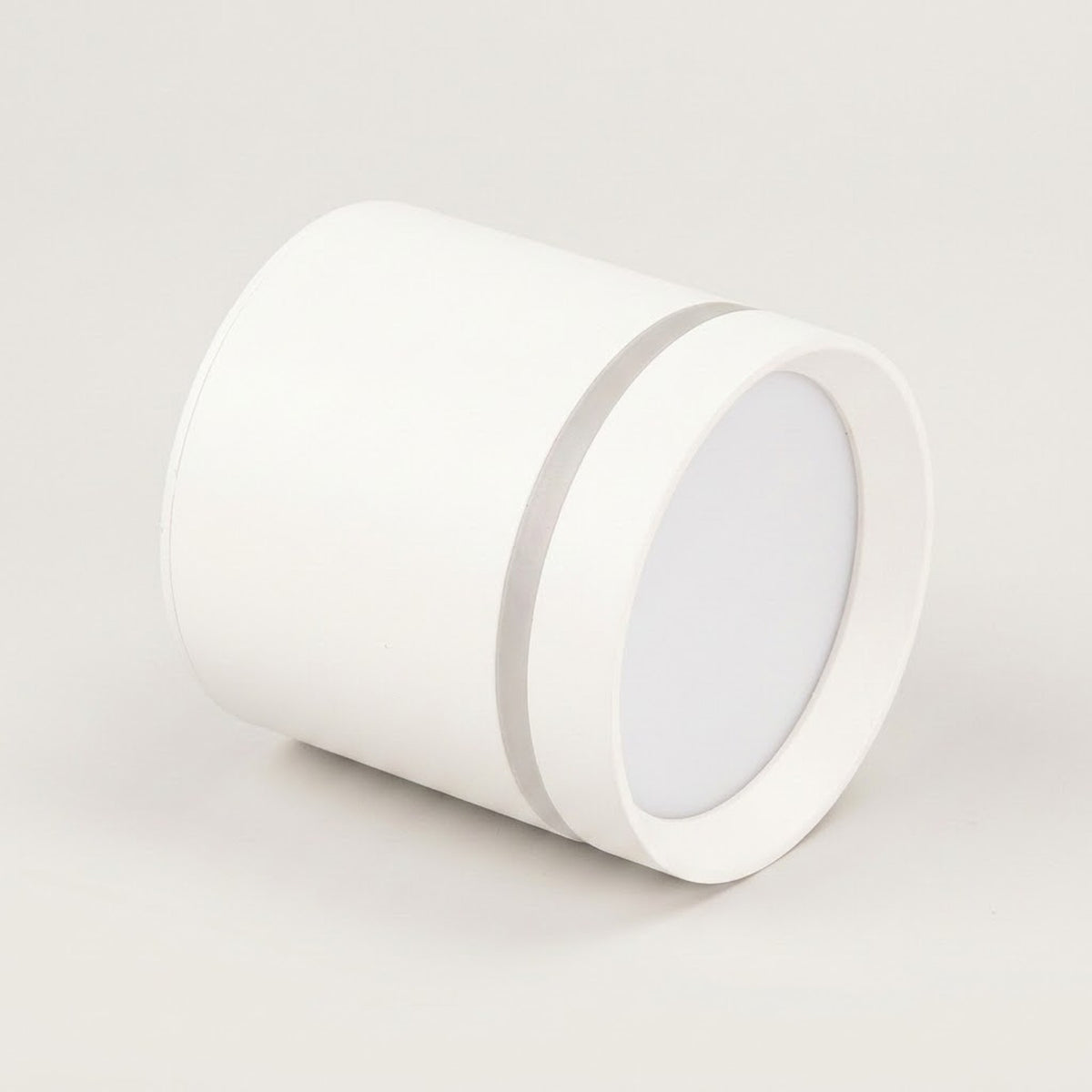 A white cylindrical LED downlight rests on its side against a light gray background, with a white diffuser and silver trim.