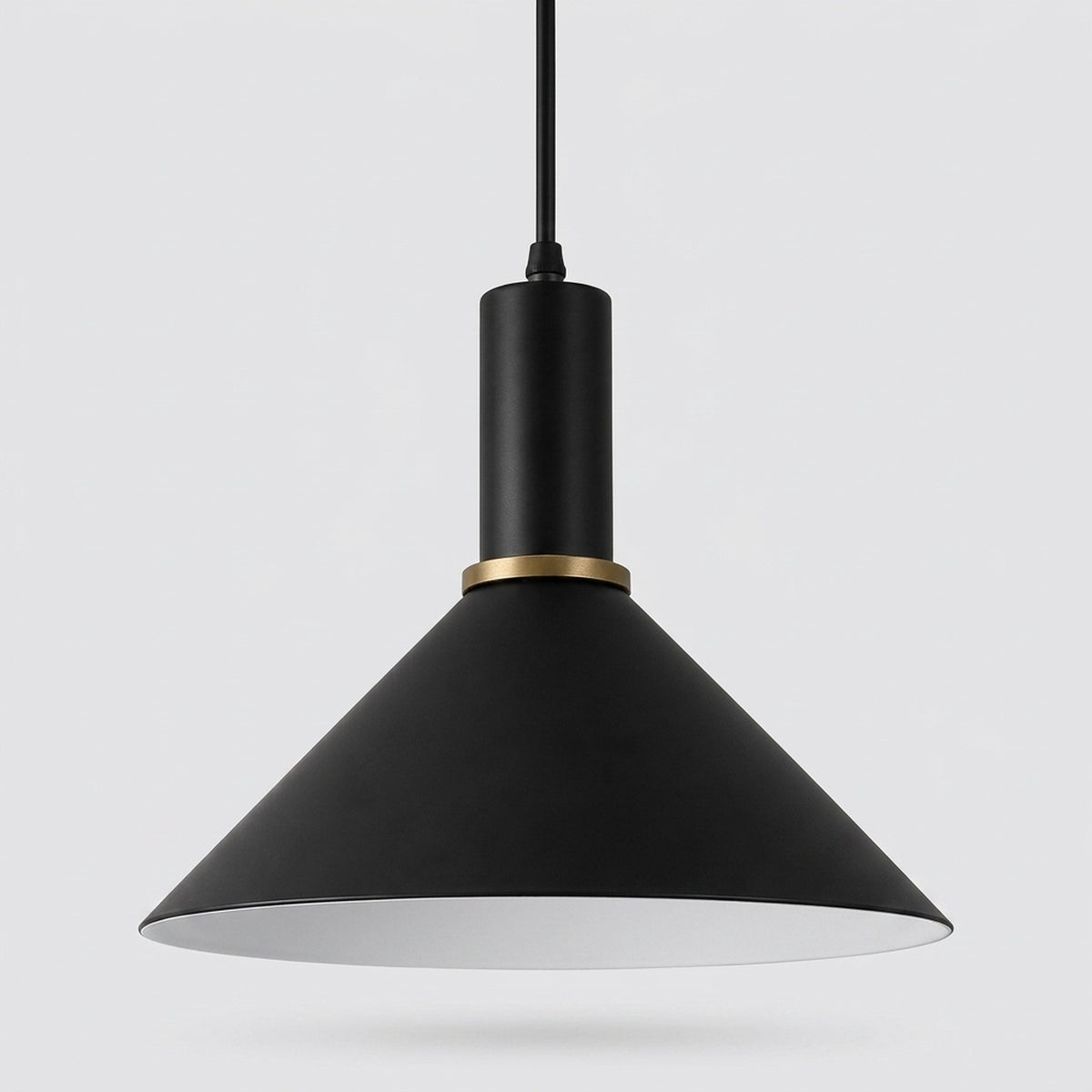 A modern black pendant light with a wide conical shade, a matte black cylindrical neck, and a thin gold accent ring, suspended against a light gray background.