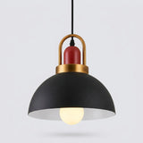 A modern pendant light with a matte black dome shade, a warm gold metal top frame, a red cylindrical accent, and a glowing light bulb inside, shown against a light gray background.