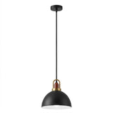 A modern pendant light with a matte black dome shade, a brass-finished metal accent ring, and a small brown wooden detail, suspended by a black cord from a matching black ceiling canopy against a white background.