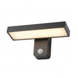 Dark wall sconce with a rectangular illuminated panel and round motion sensor is shown against a white background.