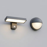 Two modern wall-mounted light fixtures on a plain light gray wall: a rectangular T-shaped sconce with a built-in motion sensor and a spherical dome-shaped sconce, both in dark gray with warm white illuminated light.
