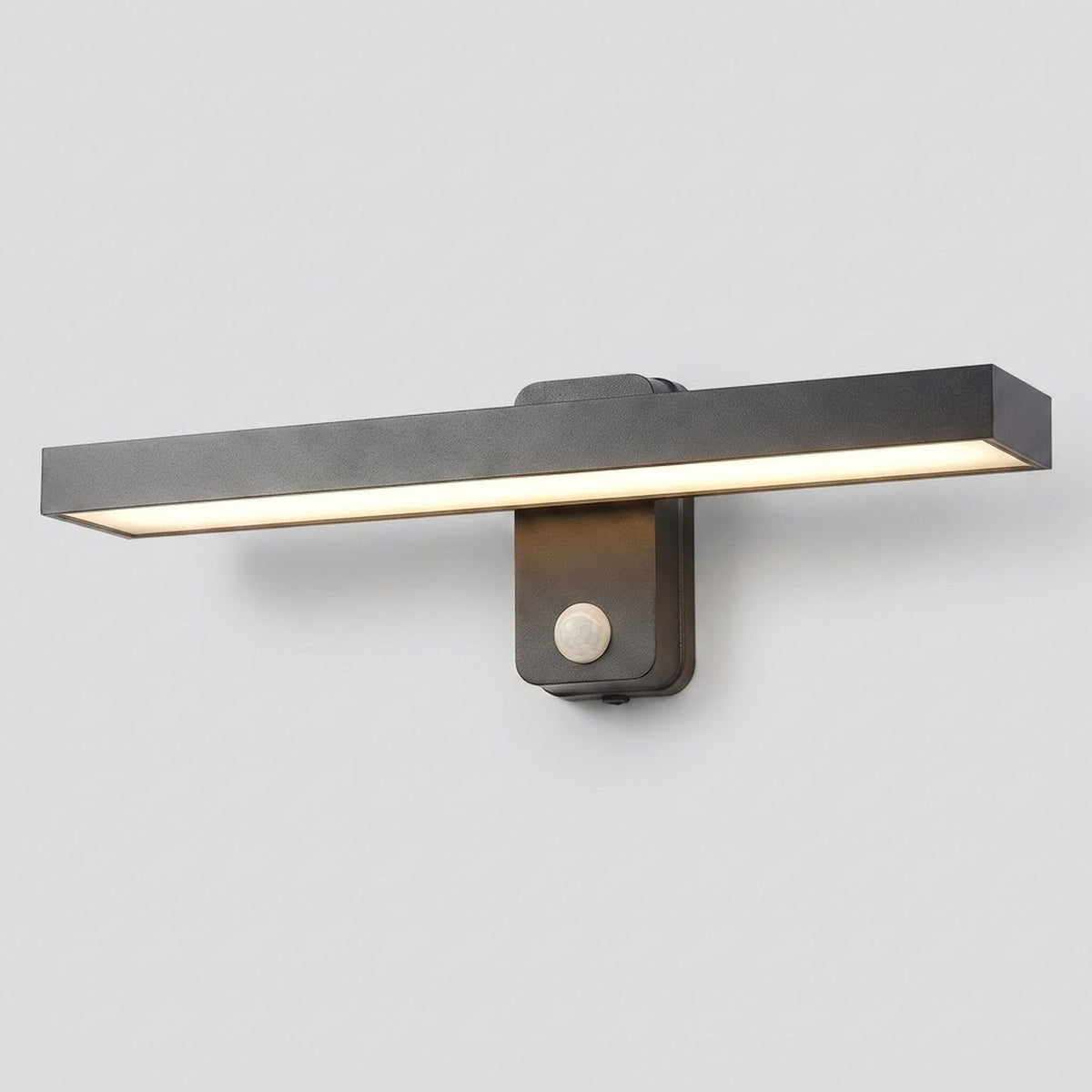 A modern linear wall sconce light fixture with a matte black rectangular bar and a warm white LED light strip, mounted on a light gray wall.