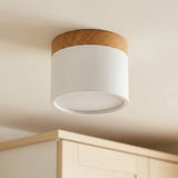 White LED downlight with wood trim and an unlit circular diffuser, mounted on a ceiling above cabinetry.