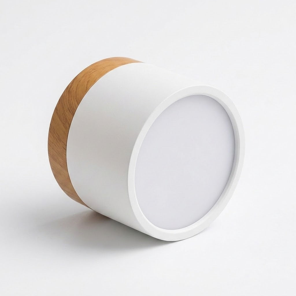 White cylindrical LED downlight with wood trim rests on its side against a white background, showing its circular diffuser.