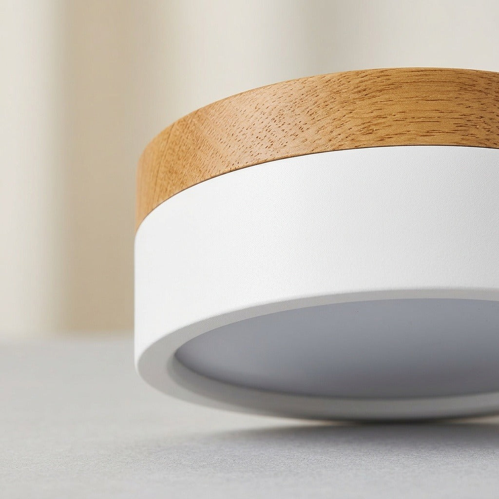 Close-up of a white LED downlight showing the wood grain trim and recessed diffuser against a neutral background.