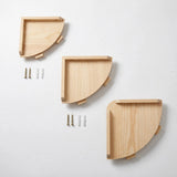 Three natural pine quarter-round corner shelves in increasing sizes on a white background, with small blocks beneath curved edges and hardware beside two shelves.