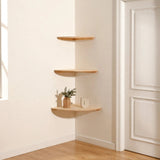 Three light natural pine quarter-round corner shelves mounted in a cream corner beside a white door, lowest holding a woven vase and face sculpture.