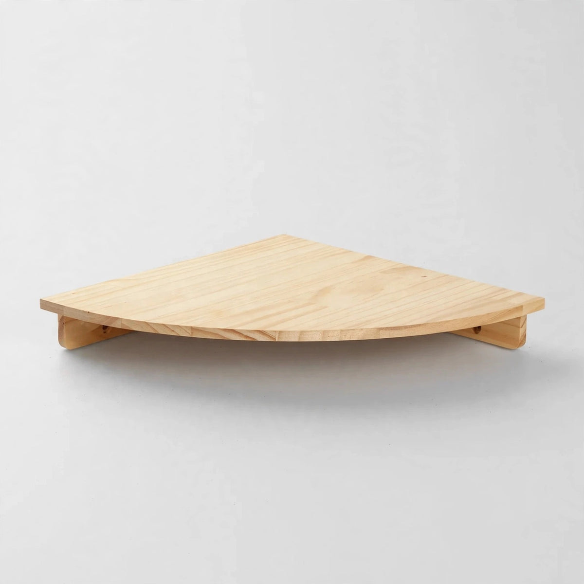 A single medium light natural pine quarter-round corner shelf with visible grain and underside cleats, shown alone against a plain white background.