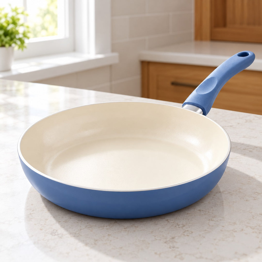 Slate Blue Ceramic Cookware Set features a smooth cream ceramic cooking surface in a bright kitchen.