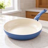 Slate Blue Ceramic Cookware Set features a smooth cream ceramic cooking surface in a bright kitchen.