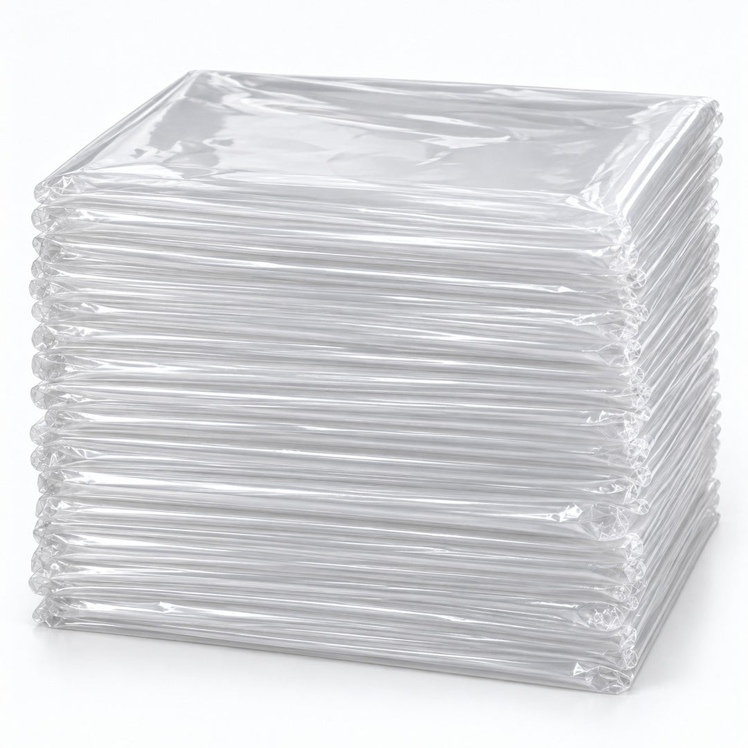 Set of 50 clear disposable plastic tablecloths folded in a substantial layered stack on a pale backdrop.