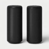 Two matte black cylindrical containers or devices standing upright side by side on a light gray studio background.