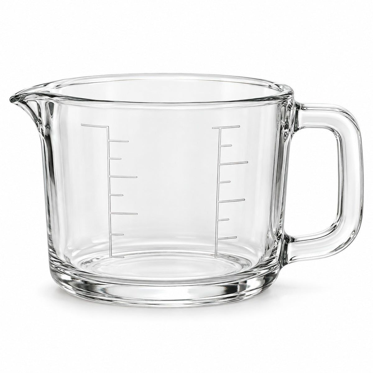 One empty clear glass 2-cup measuring cup with an integrated handle and pouring spout on white.