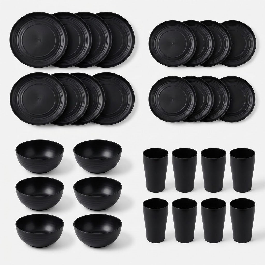 A set of matte black dinnerware, including plates, bowls, and cups, arranged neatly in rows on a light gray background.