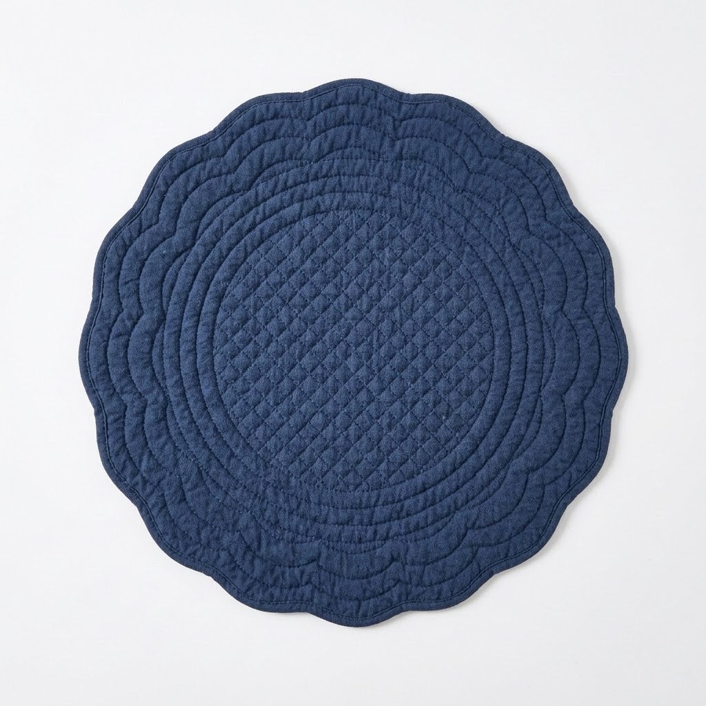A round quilted fabric play mat with a scalloped edge, shown from a top-down view on a light gray background.