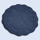 A round quilted baby play mat with a scalloped edge, featuring concentric diamond-quilted patterns in a dark navy blue color, shown on a light blue background.
