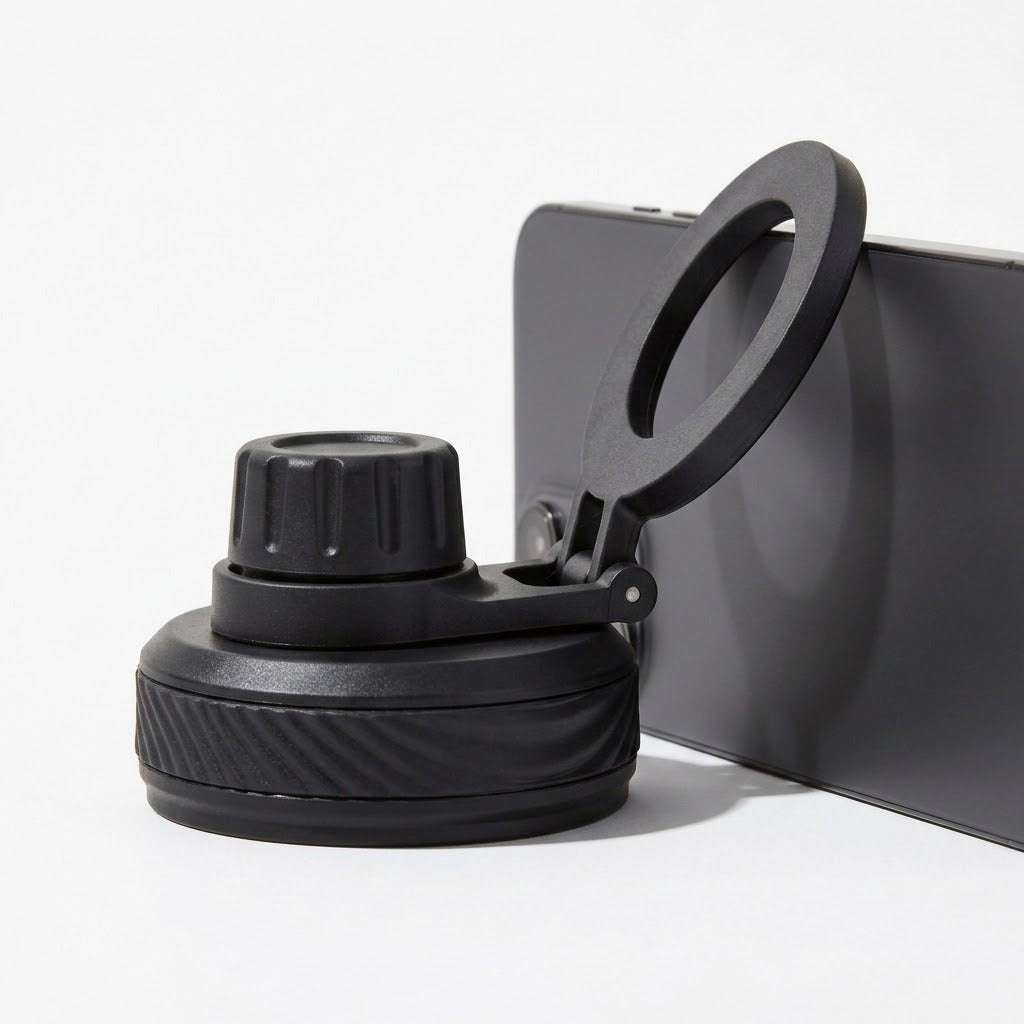 A black phone mount accessory with a circular clip and textured base, shown attached to the side of a dark smartphone on a clean white background.