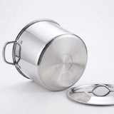 A stainless steel stockpot with a matching lid, shown on a clean white background. The pot is positioned on its side to display the bottom and side handle, with the lid resting beside it.
