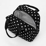 A black and white polka dot lunch bag with a silver insulated interior, shown open on a clean white background.
