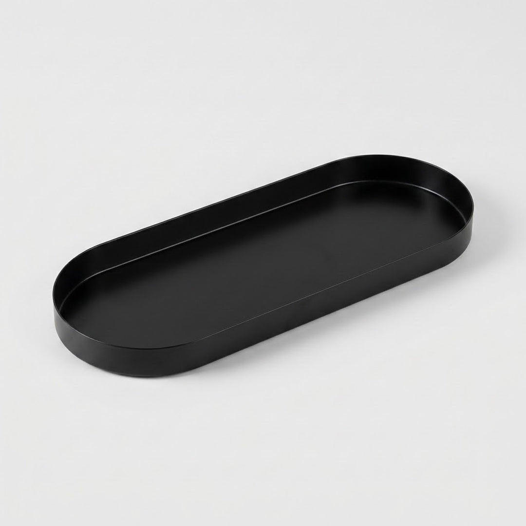 A minimalist black metal tray with a rounded rectangular shape, photographed on a clean, light gray background.