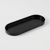 A minimalist black metal tray with a rounded rectangular shape, photographed on a clean, light gray background.