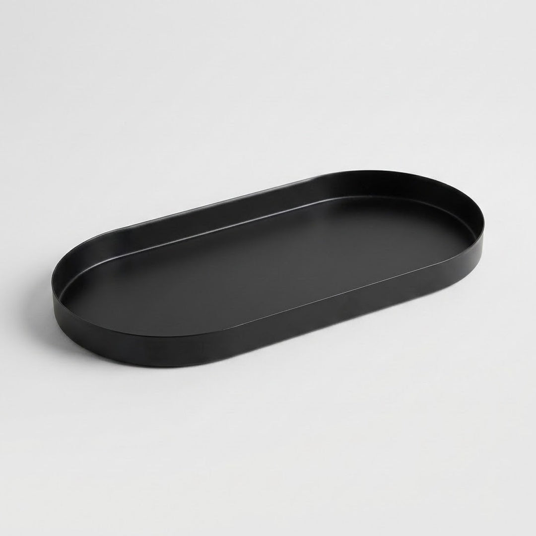 A minimalist black oval tray with a raised rim, photographed on a clean light gray background.
