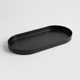 A minimalist black oval tray with a raised rim, photographed on a clean light gray background.