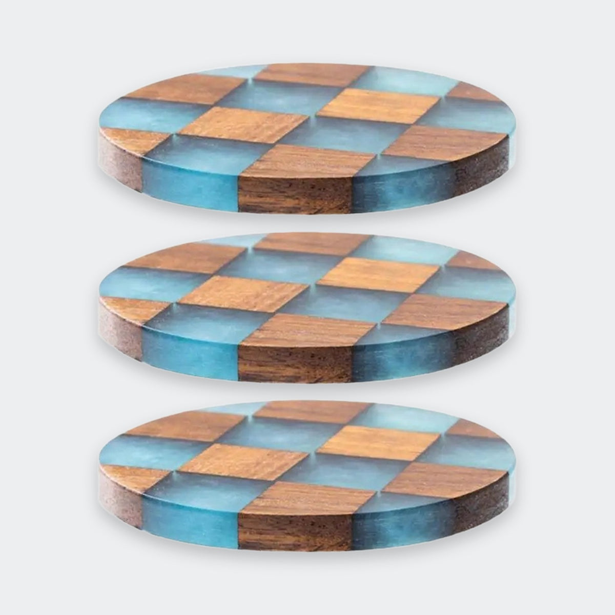 Three round wooden coasters with a blue and brown checkerboard pattern, shown on a light gray background.