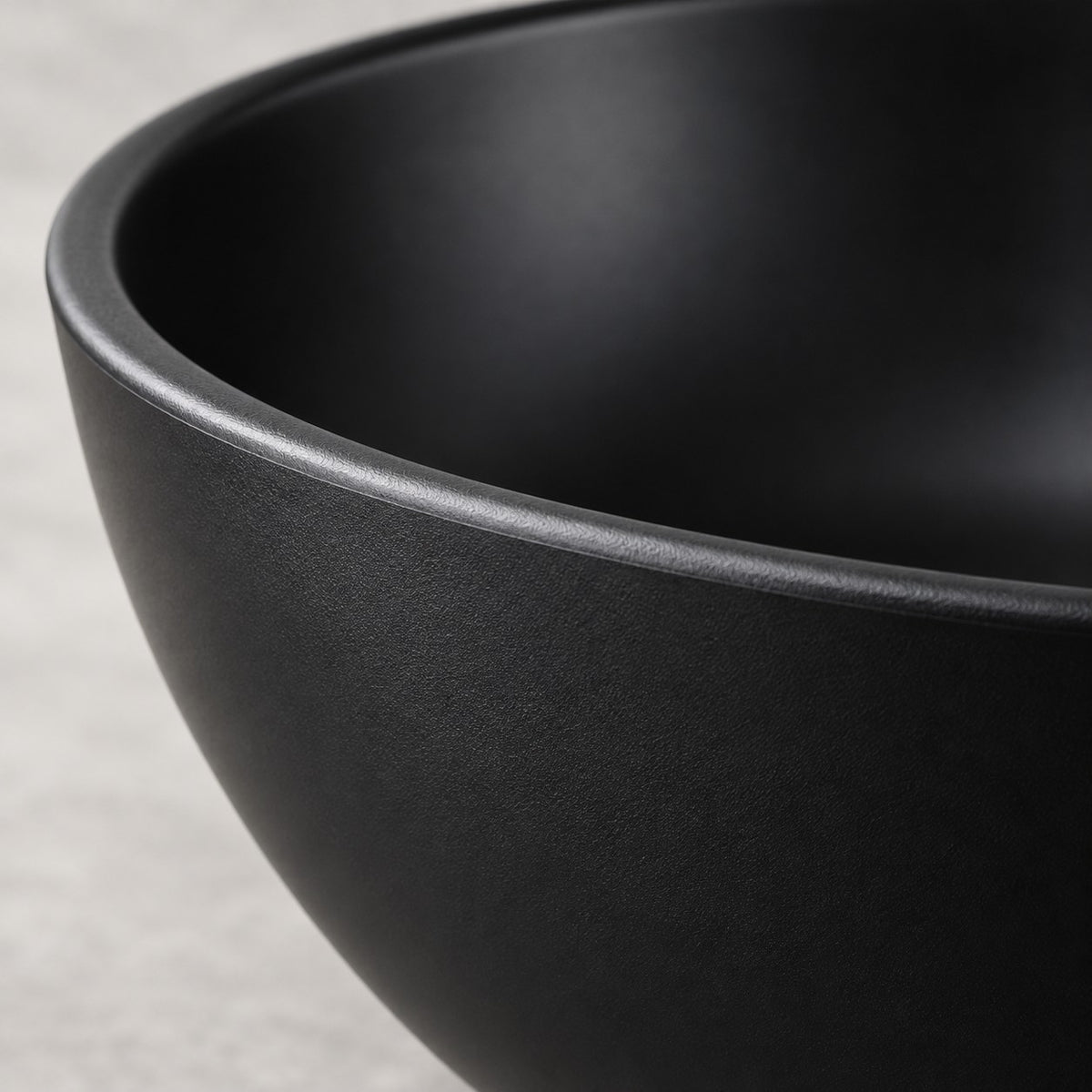 A close-up shows the smooth satin finish and rounded rim of a black Japanese-style bowl.