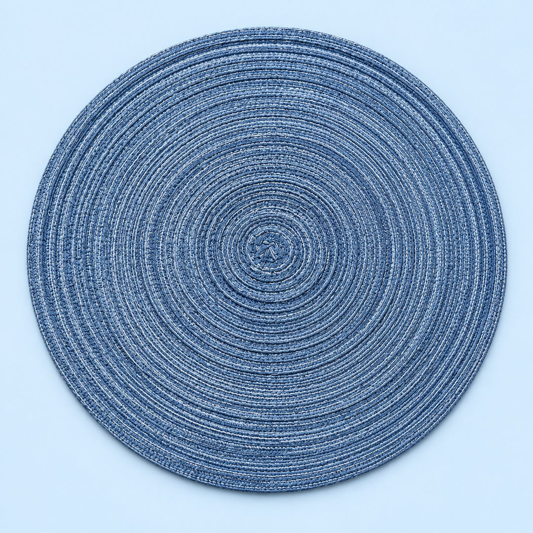 Single blue round woven polyester placemat centered on a softly tinted pale blue studio background.